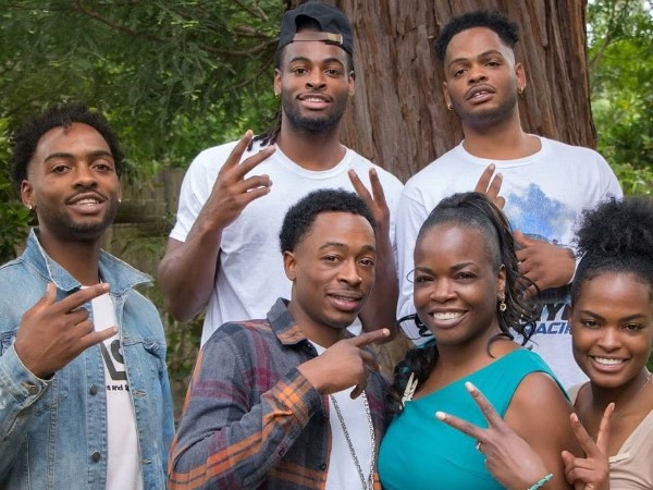 Image - Najee Harris (wearing a cap) in a family photo with his mom, Tiana, and three siblings, Curtis, Malachi, Fela, and Jahmila. 